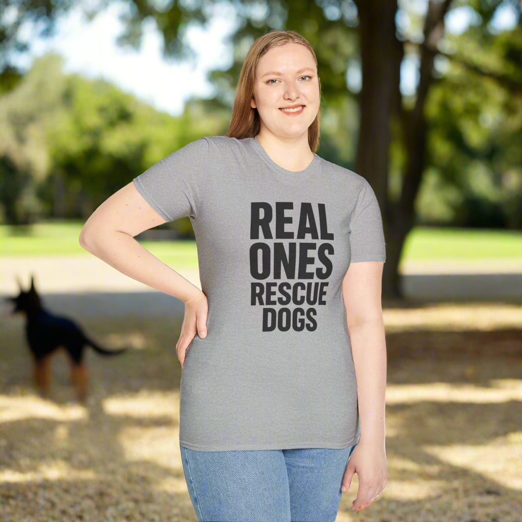 Woman wearing gray t-shirt with bold black text that reads “Real Ones Rescue Dogs”