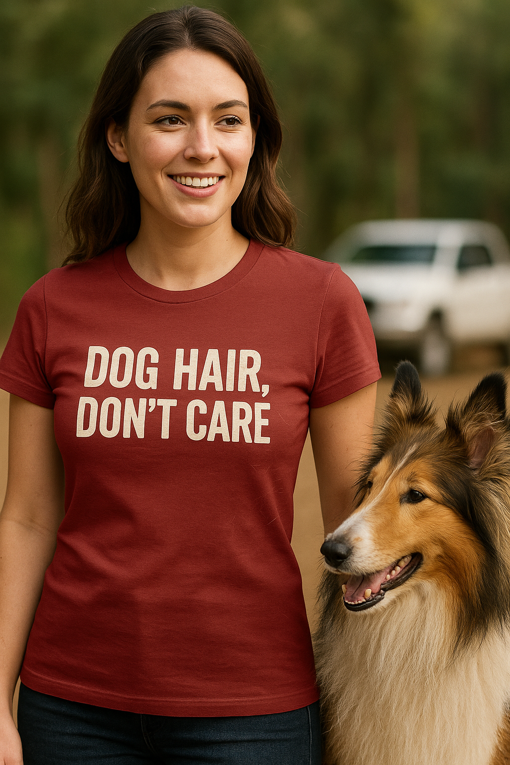 Woman wearing a brick red "Dog Hair, Don’t Care" t-shirt, standing outside with a heavily shedding Rough Collie beside her. The shirt design is printed in distressed off-white font, creating a bold but playful message perfect for messy, lovable dog life.