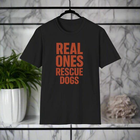 Flat lay of black t-shirt with burnt orange stacked text that reads "Real Ones Rescue Dogs"