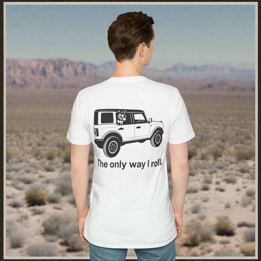 Man standing facing away wearing a white t-shirt with black graphic design of a Bronco SUV and rescue dog in the back window. The shirt reads "The only way I roll" beneath the image. Dog and vehicle are transparent silhouettes with black detail.


