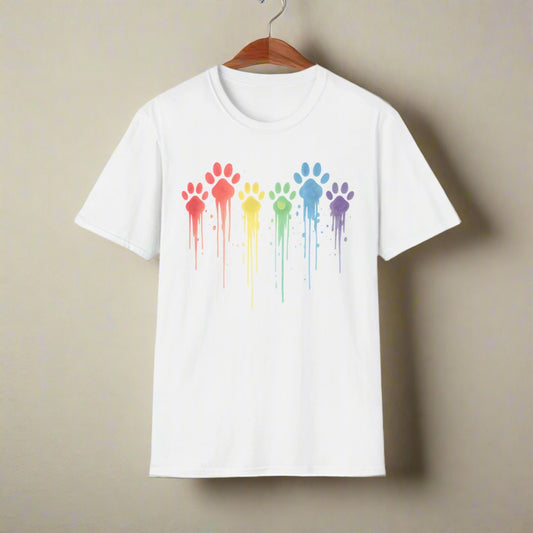 White t-shirt featuring a row of rainbow-colored paw prints with artistic paint drip effects in red, orange, yellow, green, blue, and purple.